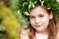 Beautiful  little girl in a white dress  in the spring wood. Portrait of the pretty little girl with a wreath from spring flowers Royalty Free Stock Photo