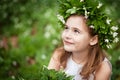 Beautiful  little girl in a white dress  in the spring wood. Portrait of the pretty little girl with a wreath from spring flowers Royalty Free Stock Photo