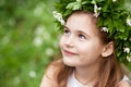 Beautiful  little girl in a white dress  in the spring wood. Portrait of the pretty little girl with a wreath from spring flowers Royalty Free Stock Photo