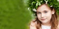 Beautiful  little girl in a white dress  in spring wood. Portrait of the pretty little girl with a wreath from spring flowers on Royalty Free Stock Photo
