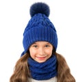 Beautiful little girl in winter warm blue hat and scarf on white. Children winter clothes