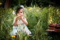 Beautiful little girl in a wreath on the head in green and white. Dress, Princess. With pleasure, but the nature Royalty Free Stock Photo