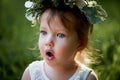 Beautiful little girl in a wreath on the head in green and white. Dress, Princess. With pleasure, but the nature Royalty Free Stock Photo