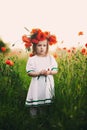Beautiful little girl with a wreath of poppies on head. cute child in wild poppies field Royalty Free Stock Photo