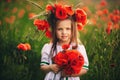 Beautiful little girl with a wreath of poppies in a white dress and a bouquet of wildflowers. cute child in poppy field Royalty Free Stock Photo