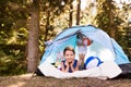 Beautiful little girls in tent camping by the lake. Royalty Free Stock Photo