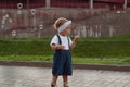 Beautiful little haired hair girl, has happy fun smiling face, pretty eyes, short hair, playing soap bubbles in white t