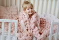 Little Girl Sitting on Bed with a Knitted Giant Plaid Royalty Free Stock Photo