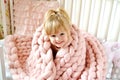 Little Girl Sitting on Bed with a Knitted Giant Plaid Royalty Free Stock Photo