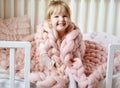 Little Girl Sitting on Bed with a Knitted Giant Plaid Royalty Free Stock Photo