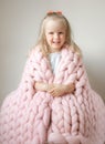 Beautiful Little Happy Blond Ginger Girl Sitting on Bed with a Pink Merino Woolen Blanket Royalty Free Stock Photo