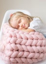 Beautiful Little Happy Blond Ginger Girl Sitting on Bed with a Pink Merino Woolen Blanket Royalty Free Stock Photo