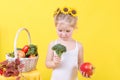 Beautiful little happy girl with basket of vegetables and fruits Royalty Free Stock Photo