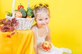 Beautiful little happy girl with basket of vegetables and fruits Royalty Free Stock Photo