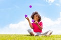 Positive happy girl juggle balls on the grass