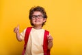 Beautiful little kid boy with backpack isolated on yellow background. Ready to go back to school. education concept Royalty Free Stock Photo