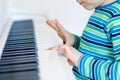 Beautiful little kid boy playing piano in living room or music school Royalty Free Stock Photo