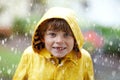 Beautiful little kid boy on way to school walking during sleet, heavy rain and snow with an umbrella on cold day. Happy Royalty Free Stock Photo