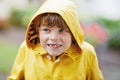 Beautiful little kid boy on way to school walking during sleet, heavy rain and snow with an umbrella on cold day. Happy and joyful Royalty Free Stock Photo