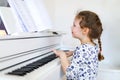 Beautiful little kid girl playing piano in living room or music school Royalty Free Stock Photo