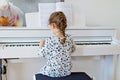 Beautiful little kid girl playing piano in living room or music school Royalty Free Stock Photo