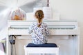 Beautiful little kid girl playing piano in living room or music school Royalty Free Stock Photo