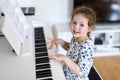 Beautiful little kid girl playing piano in living room or music school Royalty Free Stock Photo