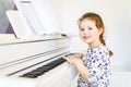 Beautiful little kid girl playing piano in living room or music school Royalty Free Stock Photo