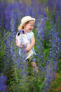 Little girl with puppy in a field with purple flowers