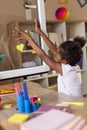 Little girl placing sticky notes on window