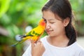 Little parrot birds standing on woman hand. Asian teenager girl play with her pet parrot bird with fun and love Royalty Free Stock Photo