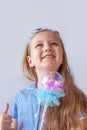 Beautiful little princess girl in silver crown holding magic wand smiling. Young lady with long wavy hair in blue dress Royalty Free Stock Photo