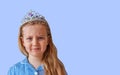 Beautiful little princess girl in sparkling silver crown.Emotional young lady with long wavy hair in blue dress portrait Royalty Free Stock Photo