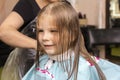 Beautiful little red-haired girl at the barber shop