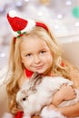 Beautiful little Santa girl near the Christmas tree. Happy girl Royalty Free Stock Photo