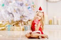 Beautiful little Santa girl near the Christmas tree. Happy girl Royalty Free Stock Photo