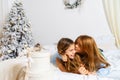 Beautiful girl giving a present to her little brother at the christmas tree Royalty Free Stock Photo