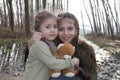 Beautiful little sisters pose with teddy bear