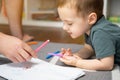 A beautiful little toddler boy of two or three years old with dad draws with markers Royalty Free Stock Photo