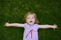 Beautiful little toddler girl happy lying on grass Royalty Free Stock Photo