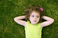 Beautiful little toddler girl happy lying on grass Royalty Free Stock Photo