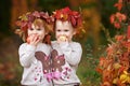 Beautiful little twin girls holding apples in the autumn garden. Little girls playing with apples. Toddler eating fruits at fall