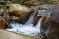 Beautiful little waterfall in mountains. Water flows between stones Royalty Free Stock Photo