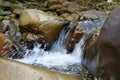 Beautiful little waterfall in mountains. Water flows between stones Royalty Free Stock Photo