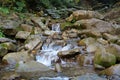 Beautiful little waterfall in mountains. Water flows between stones Royalty Free Stock Photo