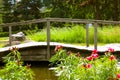 A beautiful wooden decorative footbridge over a lake river pond in summer garden Royalty Free Stock Photo