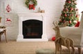 Beautiful living room interior with decorated Christmas tree and modern fireplace Royalty Free Stock Photo