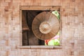 local handmade Asian hat on surface of bamboo hanging on the window of a bamboo house Royalty Free Stock Photo