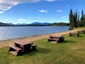 A beautiful location for a picnic with rows of picnic tables along a sandy beach overlooking a beautiful lake Royalty Free Stock Photo