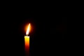 Beautiful lone candle burning against dark background